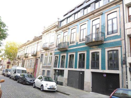 een rij gebouwen in een stadsstraat met geparkeerde auto's bij PATH Dukes Apartment in Porto