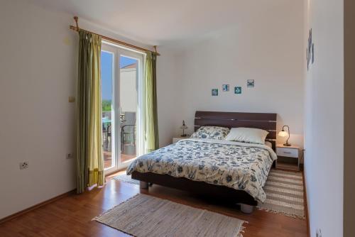 a bedroom with a bed and a large window at Apartment Monica in Ližnjan