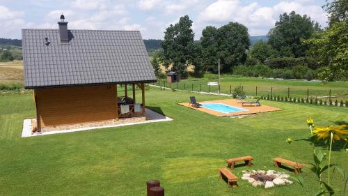 a small house with a pool in a yard at Domek Skowronek z basenem in Lesko