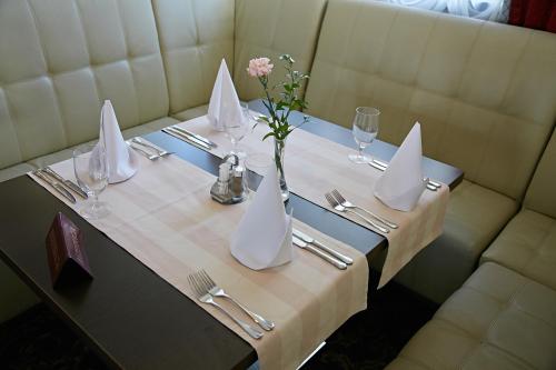 a table with napkins and a vase with a flower on it at Zamek Gniew - Pałac Marysieńki in Gniew