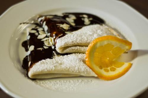 a white plate with a dessert with an orange slice at Rezydencja Eger in Kazimierz Dolny