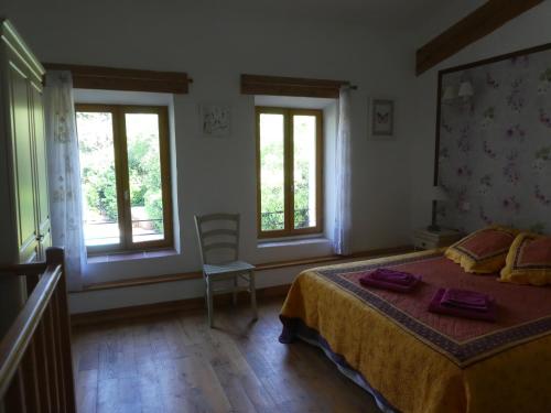 OlonzacにあるGîte Eloi Merleのベッドルーム1室(ベッド1台、窓2つ付)