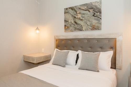 una camera da letto con letto, lenzuola e cuscini bianchi di Hotel Boutique ADAZ a Santa Marta