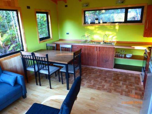 a kitchen with a table and chairs and a sink at Cabañas Latitud 41 Sur in Quillaipe