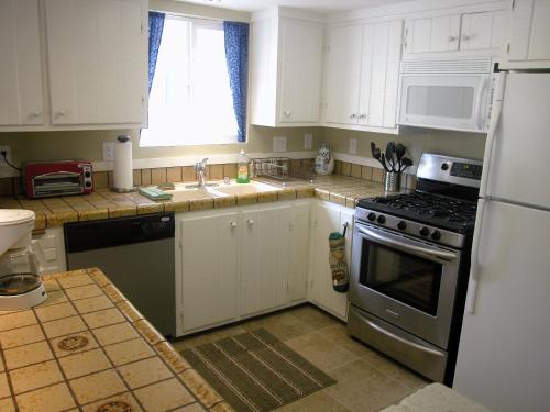 a kitchen with white cabinets and a stove top oven at Big B's Den in Big Bear Lake