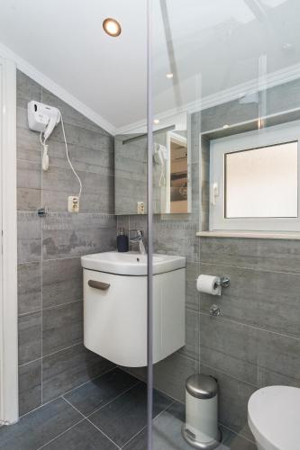 a bathroom with a toilet and a glass shower at Private room Niko in Skradin