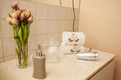 un bancone del bagno con vaso di fiori e asciugamani di ML Apartments Story a Porto