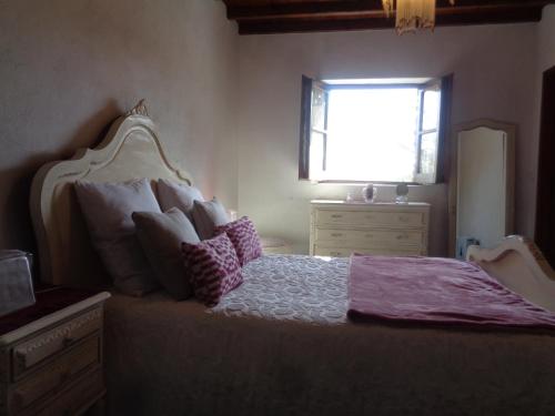 1 dormitorio con cama con almohadas y ventana en Sossego en Pedrógão Grande