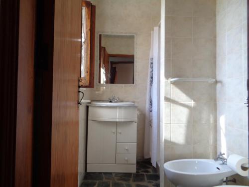 a bathroom with a sink and a toilet and a mirror at Sossego in Pedrógão Grande