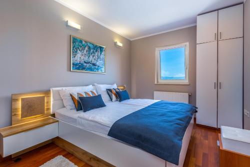 a bedroom with a large bed with blue sheets at Villa Nada in Lovran