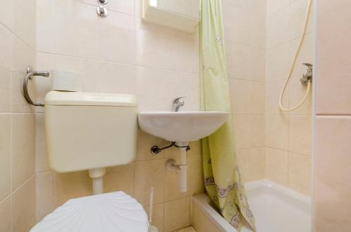 a bathroom with a toilet and a sink at Apartments Mime in Pirovac
