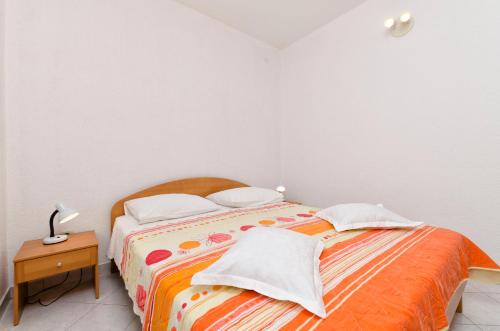 a bed with two pillows on it in a bedroom at Apartments Mime in Pirovac