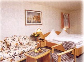 a hotel room with a couch and a bed at Hotel Gasthof Hirsch in Alfdorf