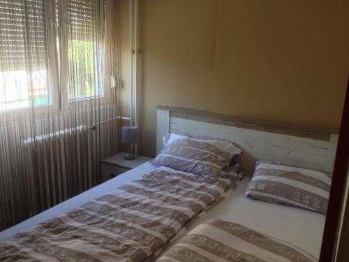 un letto con due cuscini sopra in una camera da letto di Markoni a Pančevo