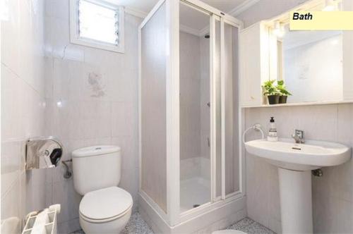 Baño blanco con aseo y lavamanos en Apartamento Joel, en Barcelona