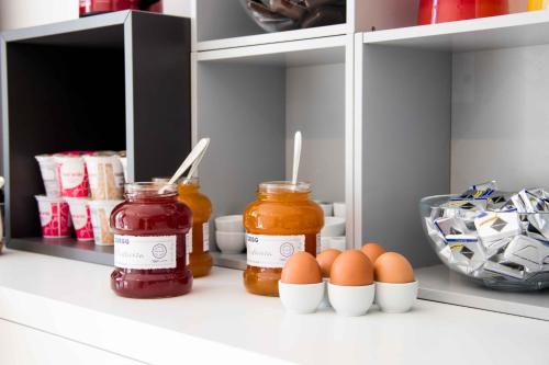 a kitchen pantry with eggs and jars of preserves at Hotel Rossovino Como in Como