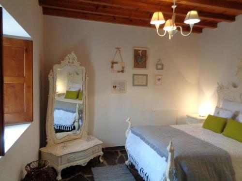 Schlafzimmer mit einem Bett und einem Spiegel in der Unterkunft Casa do Retiro in Pedrógão Grande