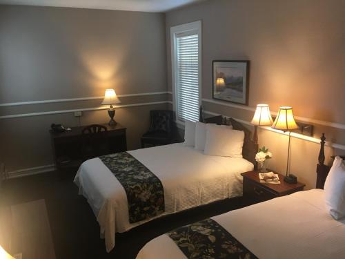 um quarto de hotel com duas camas e duas lâmpadas em Kalispell Grand Hotel em Kalispell