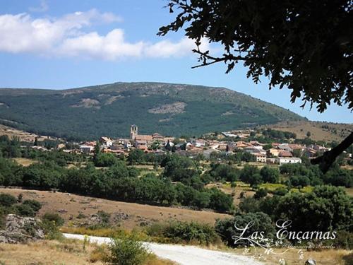 a small town in a field with a mountain at Las Encarnas in Braojos de la Sierra