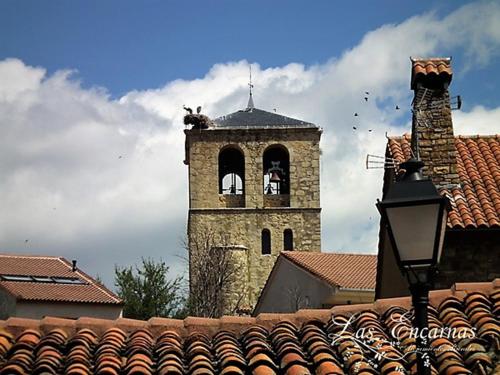 a building with a tower with a bell tower at Las Encarnas in Braojos de la Sierra