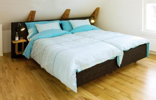 a bedroom with a large bed with blue pillows at Annas Hotell in Kristianstad