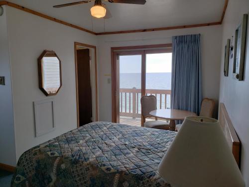a bedroom with a bed and a view of the ocean at Algoma Beach Motel in Algoma