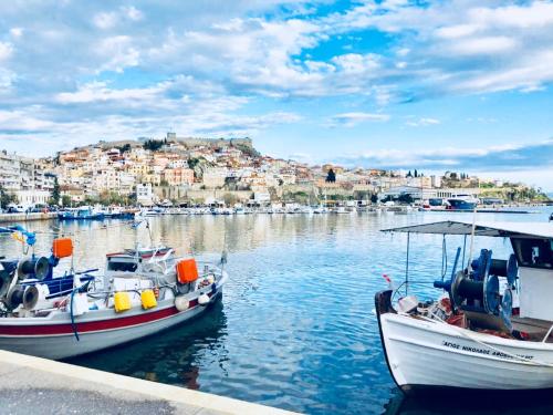 dos barcos están atracados en un puerto con una ciudad en Apartments@Tsiantas en Kavala