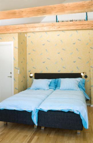 a bed in a room with a wall at Annas Hotell in Kristianstad