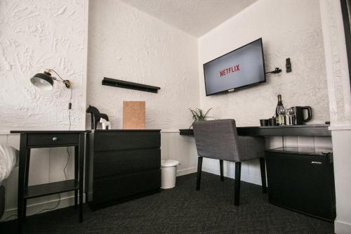 a room with a desk and a tv on the wall at Hotel Villa Hakuba by HHG in Hakuba