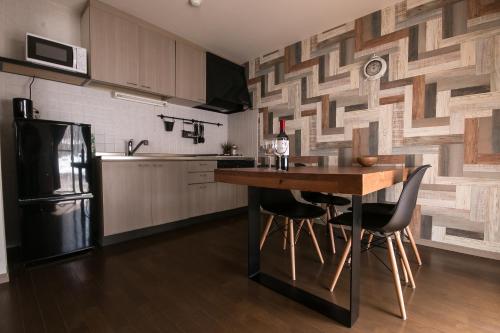 a kitchen with a wooden table and a refrigerator at Hotel Villa Hakuba by HHG in Hakuba