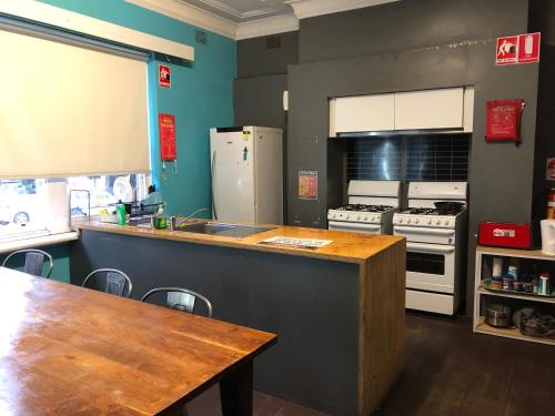 a kitchen with a table and a counter with appliances at South Yarra Hostel in Melbourne