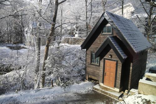 a small dog house with a brown door in the snow at Hotel Villa Hakuba by HHG in Hakuba