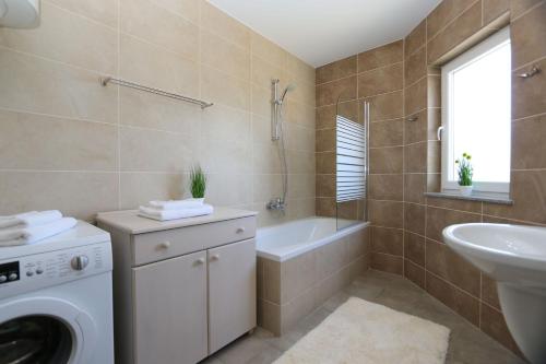 y baño con lavadora y lavamanos. en Apartment Soline Cove, en Soline
