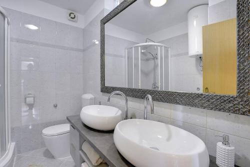 a bathroom with a sink and a toilet and a mirror at Apartment Falu in Štinjan
