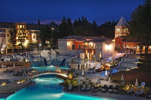 a resort with a swimming pool at night at Hotel Garden Istra Plava Laguna in Umag