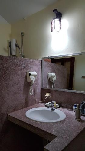 a bathroom with a sink with a mirror and a light at Mealea Resort in Kep