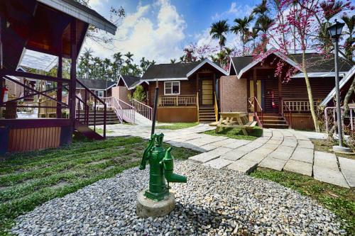 a green fire hydrant in front of a house at 杉溪鹿莊園-溪頭獨棟式小木屋 & 如需溜滑房型請選請選家庭房 in Lugu