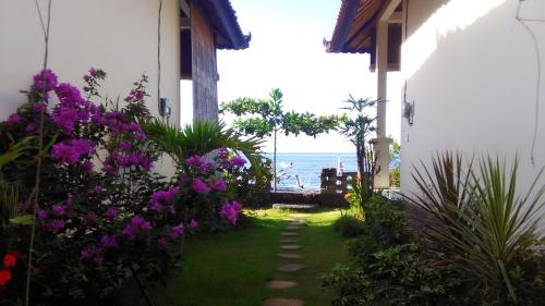 a pathway leading to a house with a view of the ocean at Tambun Sari Beach Homestay in Amed