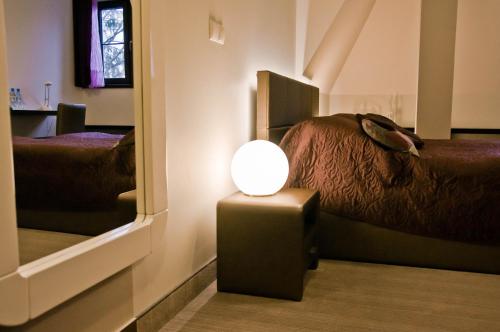a room with a bed and a lamp on a table at Rezydencja Eger in Kazimierz Dolny