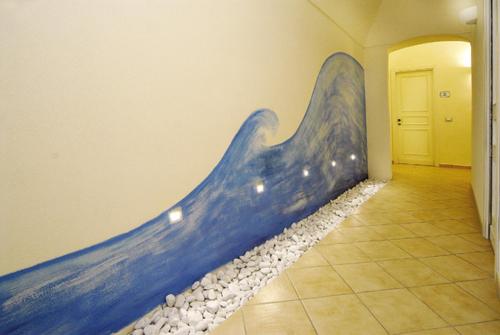 a painting of a blue wave on a wall at Hotel Vita Serena in Arma di Taggia