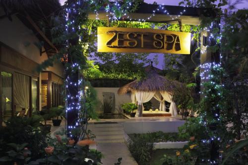 a garden with a first spa sign and lights at The Cliff Resort & Residences in Mui Ne