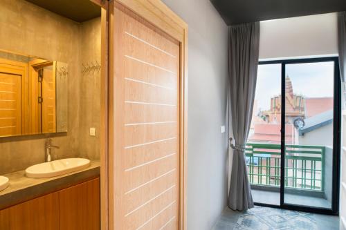 un bagno con lavandino e una porta con finestra di RS III Location Hostel a Phnom Penh