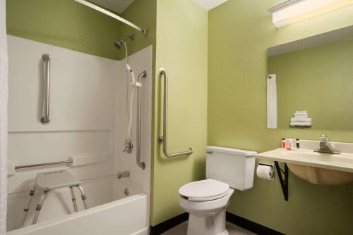 baño verde con aseo y lavamanos en Super 8 by Wyndham Ithaca, en Ithaca