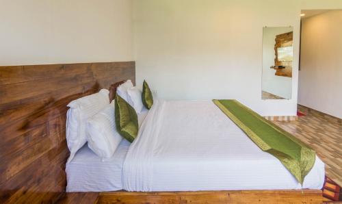 a bedroom with a bed with white sheets and pillows at Treebo Lands End Beach Resort Morjim in Morjim