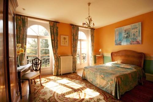 une chambre avec un lit, un bureau et des fenêtres dans l'établissement Domaine de Sainte Anne, à Venoy