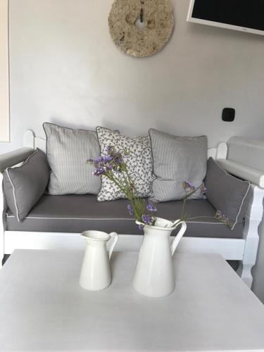 a living room with a couch and two vases on a table at Spitaki Serifos Studio in Rámos