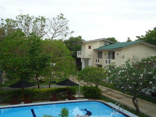 a swimming pool in front of a house at The Kent in Tissamaharama