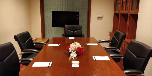 una sala de conferencias con una mesa con flores. en Jaypee Vasant Continental en Nueva Delhi