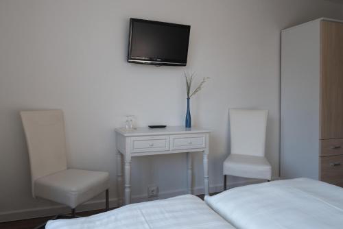 a bedroom with a bed and a tv on the wall at Haus ÜberLand in Sundhagen