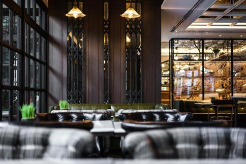 a dining room with couches and a bar at Tastoria Collection Sukhumvit in Bangkok